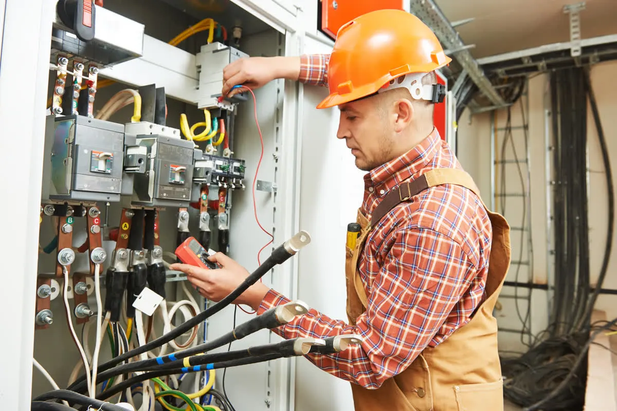Electrician testing a distribution board with a multimeter